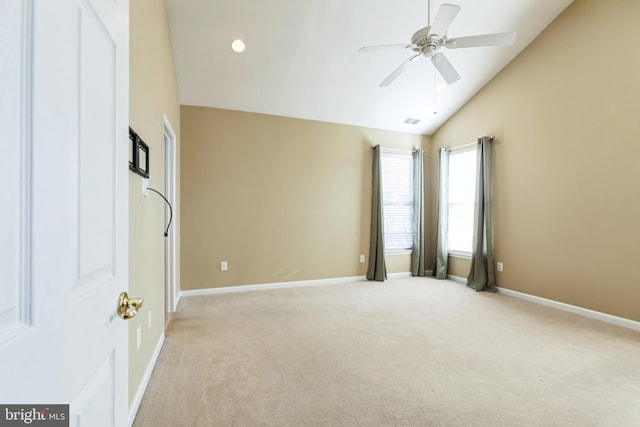 empty room featuring light carpet, visible vents, baseboards, and vaulted ceiling