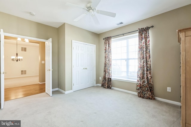 unfurnished bedroom featuring baseboards, visible vents, and light colored carpet