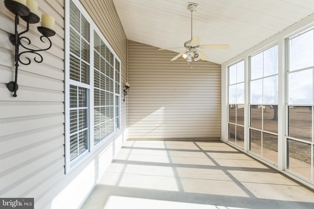 unfurnished sunroom with lofted ceiling and a ceiling fan