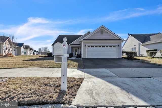 view of front of house featuring driveway, an attached garage, a residential view, and a front yard