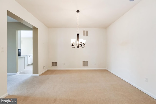 unfurnished dining area with an inviting chandelier, visible vents, and light colored carpet