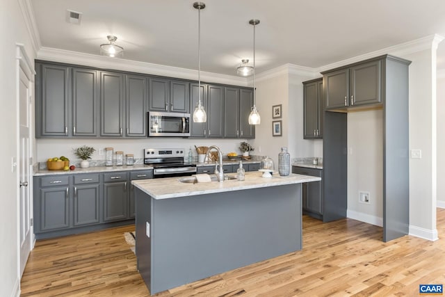 kitchen with hanging light fixtures, appliances with stainless steel finishes, and gray cabinets