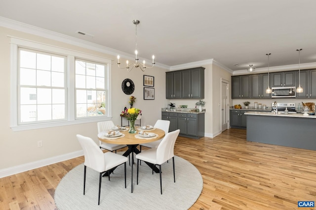 dining space featuring light wood finished floors, visible vents, ornamental molding, a chandelier, and baseboards