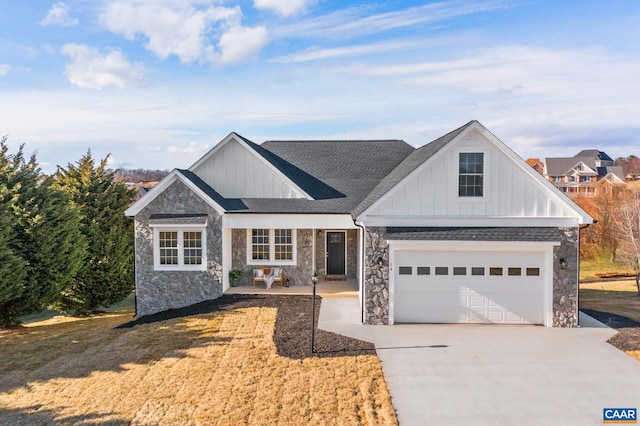 view of front of house featuring a shingled roof, board and batten siding, a garage, driveway, and a front lawn