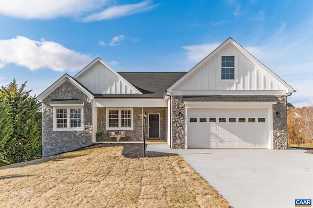 view of front of house with a shingled roof, concrete driveway, board and batten siding, a front yard, and a garage