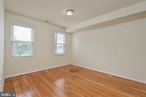 unfurnished room with baseboards and wood finished floors