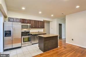 kitchen with dark brown cabinets, recessed lighting, a kitchen island, and stainless steel appliances
