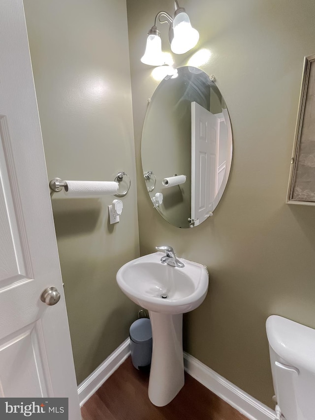 bathroom with a sink, toilet, and baseboards