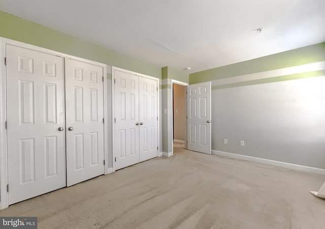 unfurnished bedroom featuring baseboards and multiple closets