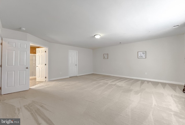 spare room featuring light carpet, visible vents, and baseboards