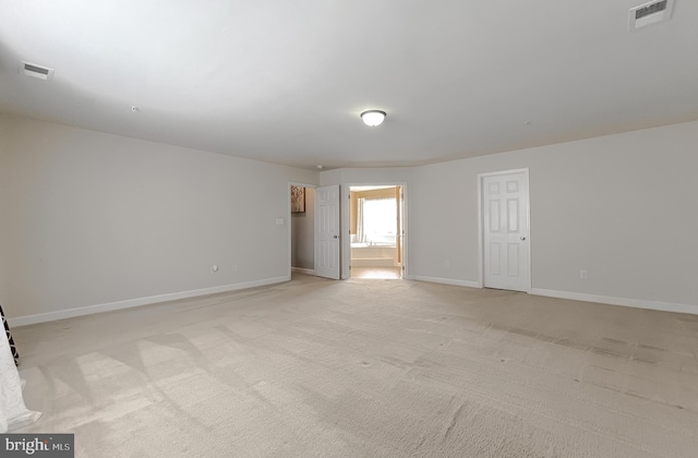 empty room with light carpet, visible vents, and baseboards