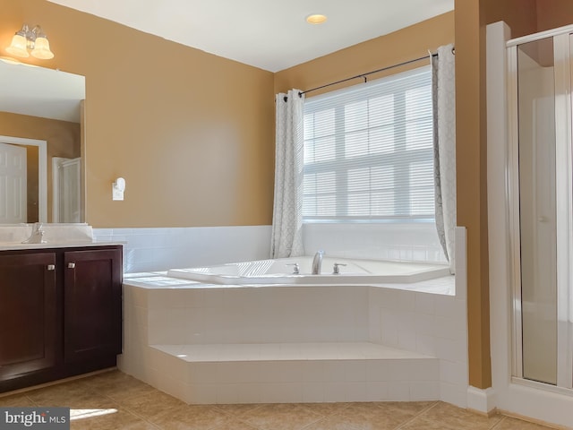 bathroom featuring a shower stall, a garden tub, tile patterned floors, and vanity