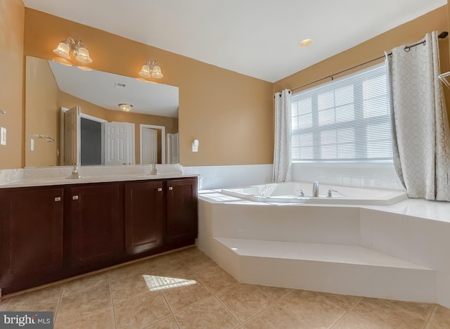 bathroom featuring a garden tub, tile patterned floors, and vanity