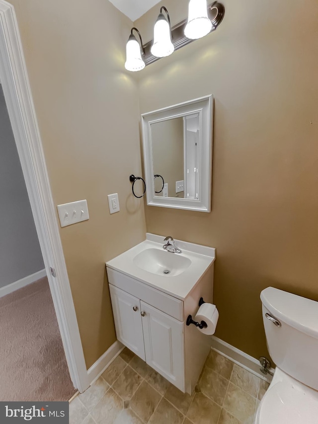 bathroom featuring toilet, tile patterned floors, baseboards, and vanity