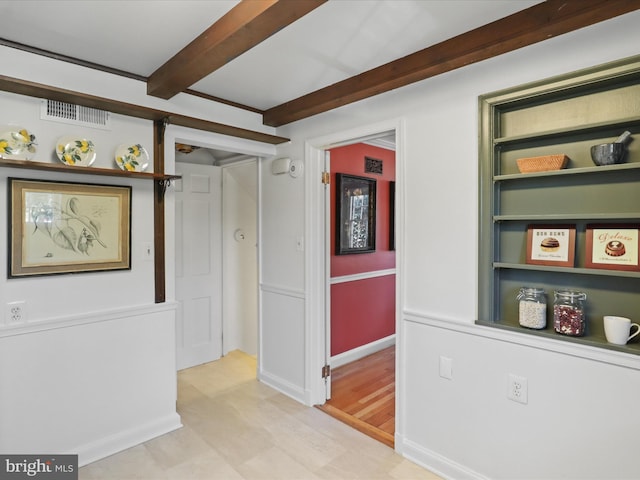 hallway featuring beam ceiling and visible vents