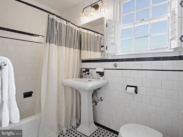 full bath featuring toilet, tile walls, and shower / bath combo