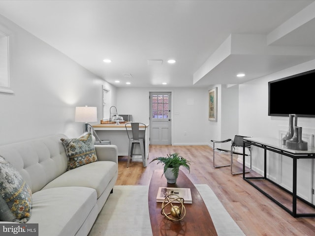 living area with recessed lighting, light wood-style floors, and baseboards