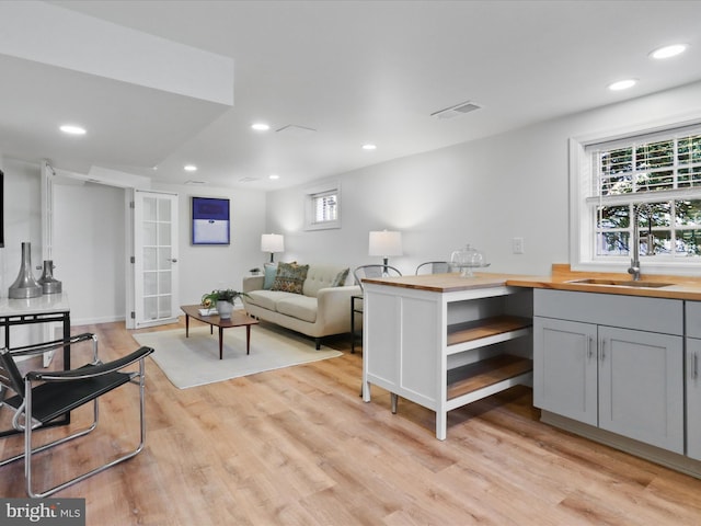 living room featuring light wood finished floors, visible vents, and recessed lighting