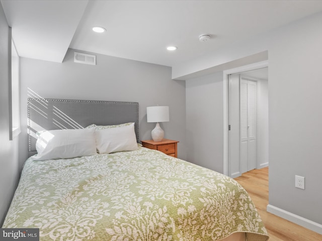 bedroom featuring light wood finished floors, visible vents, recessed lighting, and baseboards