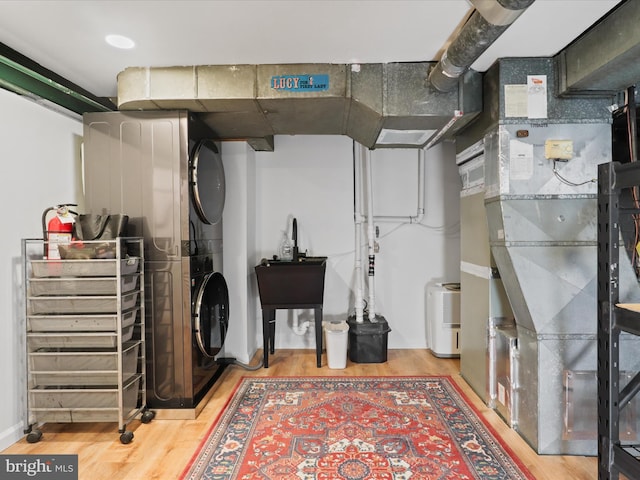 finished below grade area featuring stacked washer and dryer and wood finished floors