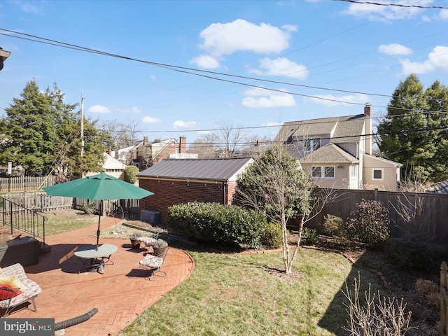 view of yard with a patio area, an outbuilding, and a fenced backyard