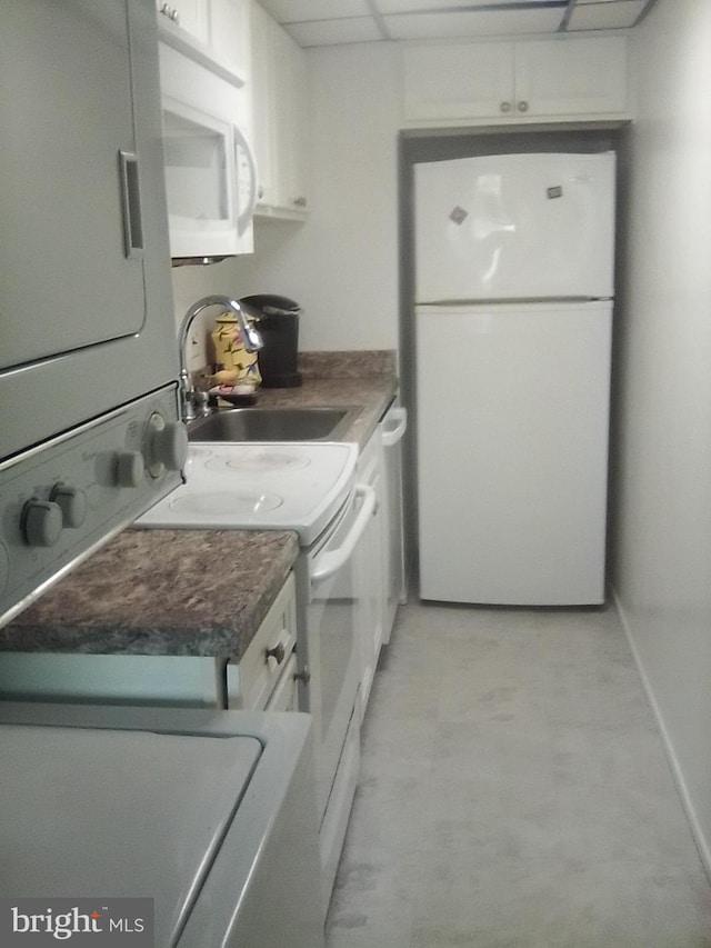 laundry area featuring laundry area, a sink, and stacked washer and clothes dryer