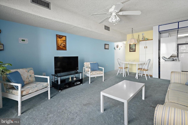 carpeted living area featuring a textured ceiling, ceiling fan, and visible vents