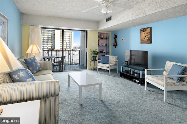 living room with carpet, visible vents, ceiling fan, and a textured ceiling