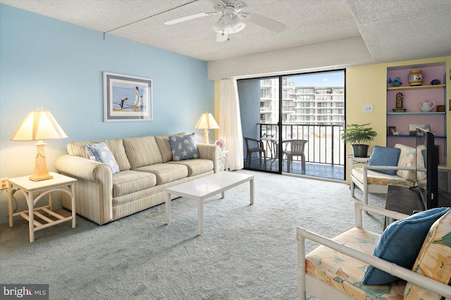 living area featuring a textured ceiling, carpet floors, and a ceiling fan