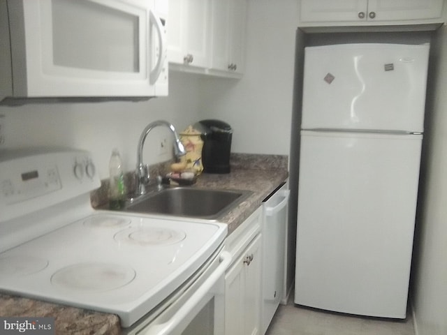 kitchen featuring white appliances, white cabinetry, and a sink