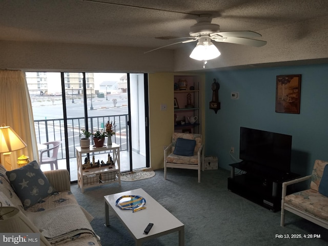 carpeted living area featuring a textured ceiling and ceiling fan