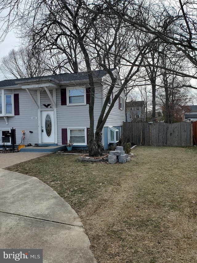 bi-level home featuring fence and a front lawn