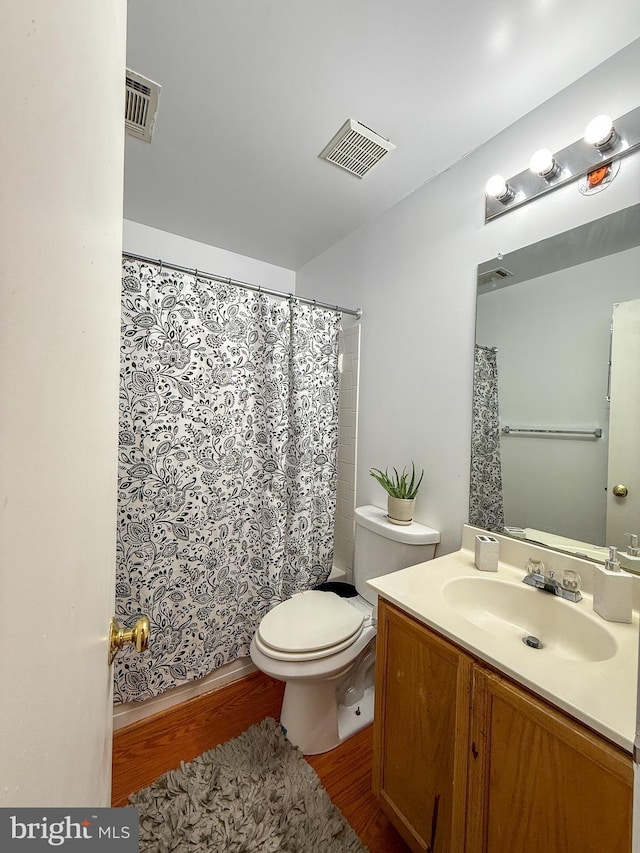 full bathroom featuring toilet, wood finished floors, vanity, and visible vents