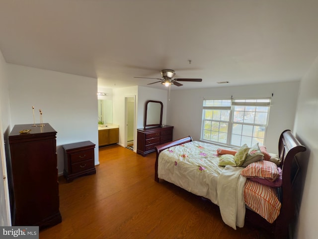 bedroom with ceiling fan, wood finished floors, visible vents, and connected bathroom