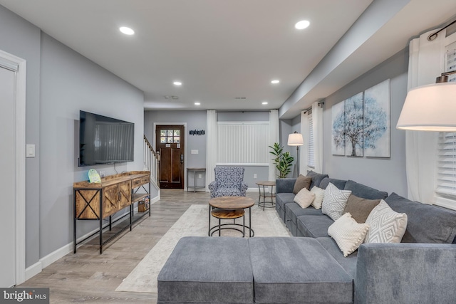 living room with baseboards, stairway, light wood-style flooring, and recessed lighting