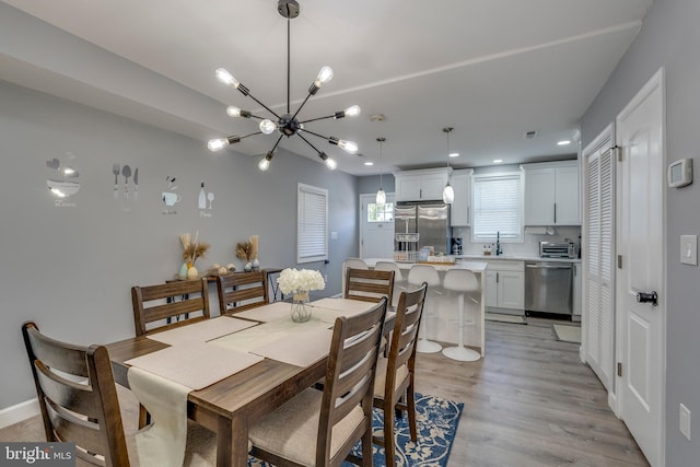 dining space featuring a chandelier, recessed lighting, light wood-type flooring, and a toaster