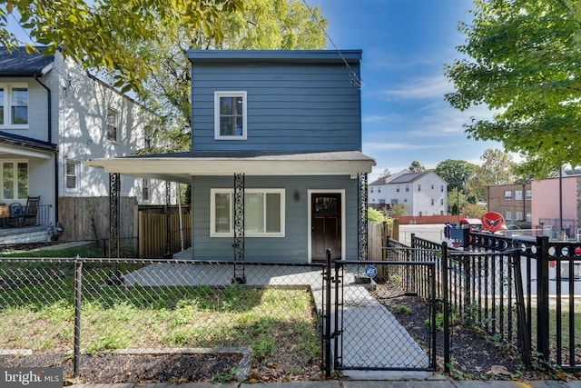 view of front of house with a fenced front yard, a gate, and a porch