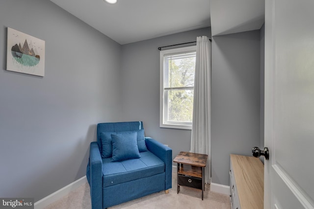 sitting room featuring light colored carpet and baseboards