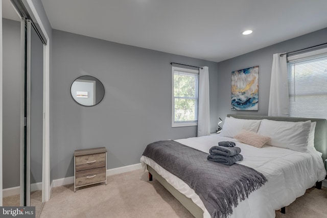 bedroom featuring light carpet, a closet, recessed lighting, and baseboards