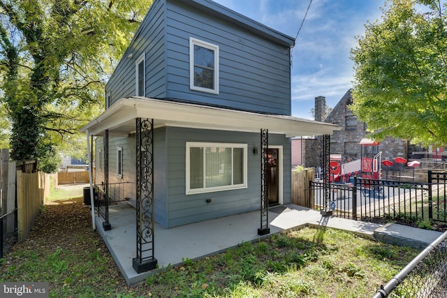 view of front facade featuring fence and central AC unit