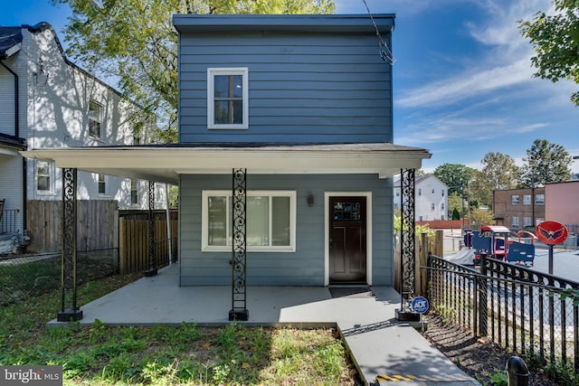 view of front of house featuring a porch and fence