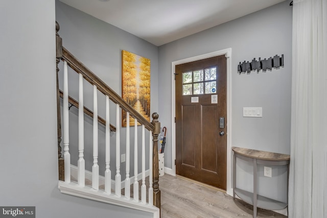 entryway with light wood-type flooring and stairs