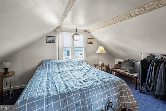 bedroom featuring a textured ceiling, dark carpet, lofted ceiling, and baseboards