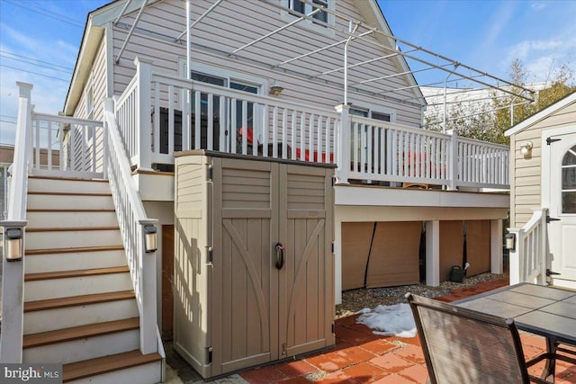 back of house featuring a shed, stairway, and an outdoor structure