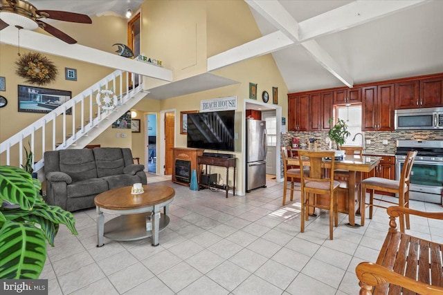 living room with a ceiling fan, stairs, a fireplace, beam ceiling, and light tile patterned flooring