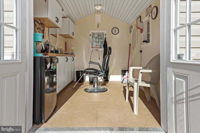 interior space featuring light countertops, white cabinets, and vaulted ceiling