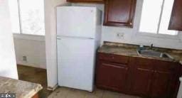 kitchen with freestanding refrigerator and a sink