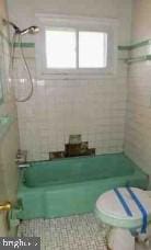 bathroom with shower / bathing tub combination and toilet