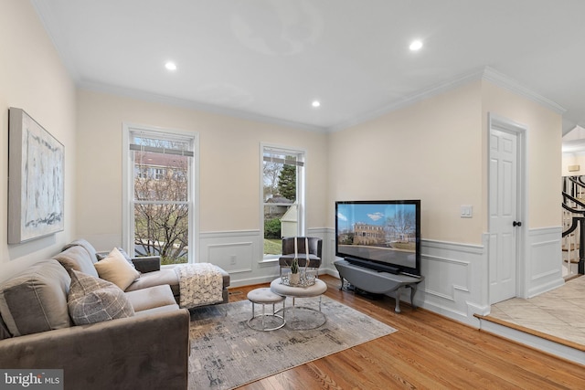 living room with a wainscoted wall, ornamental molding, wood finished floors, and recessed lighting