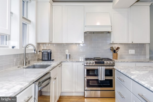 kitchen featuring appliances with stainless steel finishes, a sink, and white cabinetry